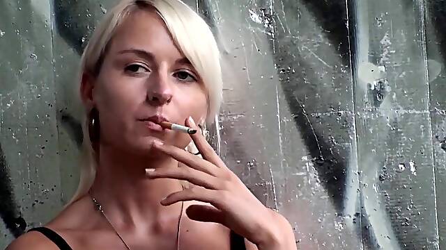 Lovely blonde teen smoking a cigarette outdoors by Femdom Austria