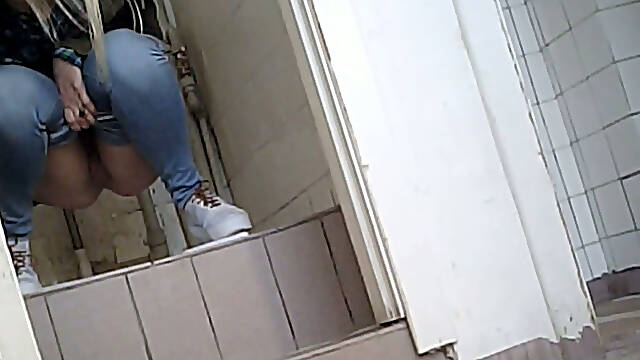Lovely amateur lady in blue jeans filmed in the public restroom