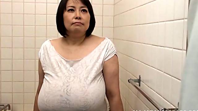 Huge-breasted mature Japanese lady gives a titjob to a horny man