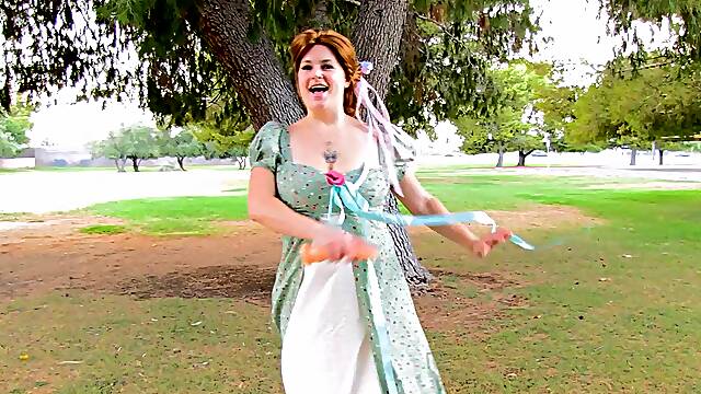 Busty redhead hussy fucks her twat with a dildo in a park