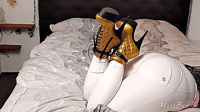 BWB MissBigButt modeling her bevy of shoes in white freddy pants and black shiny latex corsage in couch