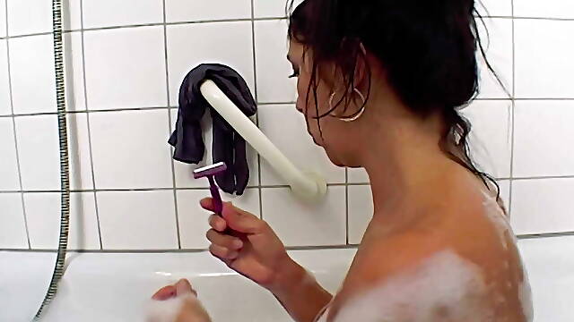 Dark haired German beauty pleasing herself in the bathroom