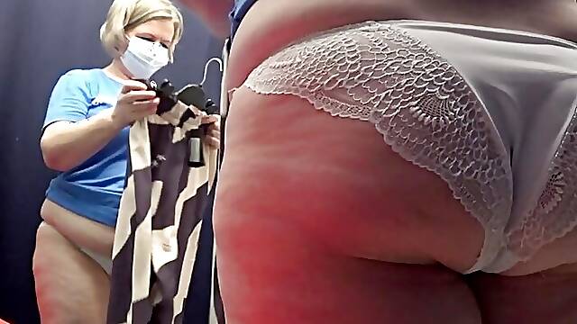The camera in the fitting room watches a big butt in white panties. Curvy milf tries on pants....
