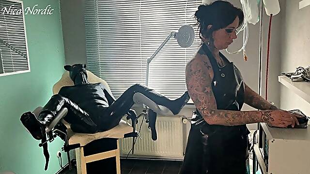 Rubber pig jerked off on the gynecological chair under current in rubber apron