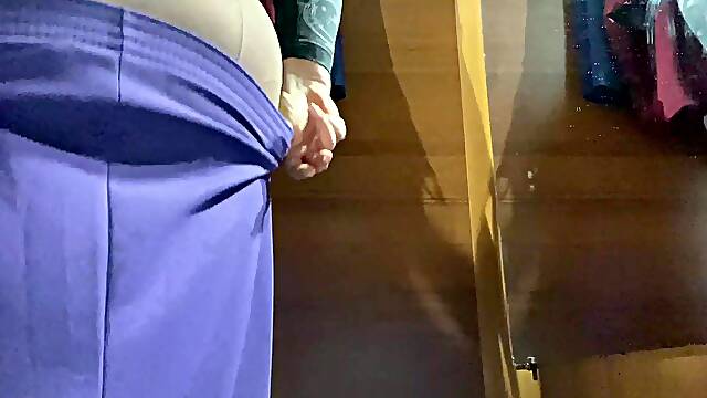 Curvy MILF in the mall fitting room trying on skirts.