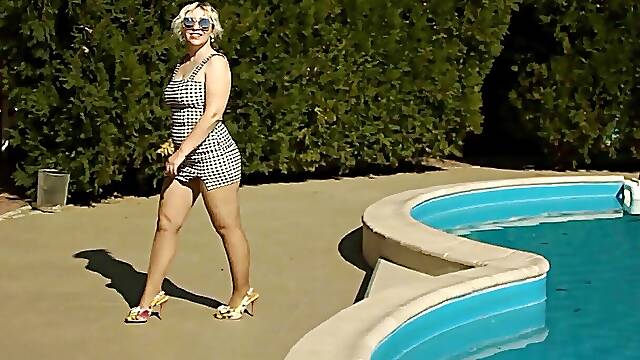 Pretty woman by the pool in pantyhose and heels